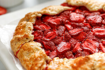 Strawberry galette. Open strawberry pie on marble board. Homemade pastry, baked cake with strawberry.