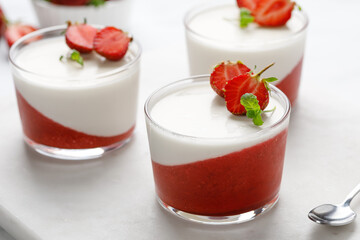 Panna cotta with strawberry in a glass jars decorated with fresh berries and mint, Traditional Italian sweet dessert. Strawberry creamy dessert - panna cotta.