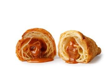 Fototapeta premium Half of Fresh baked Croissant with liquid caramel inside isolated on white background. Delicious french croissant.