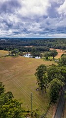 Vertical aerial view of fields and forest under the cloudy sky in the countryside of Fernbank Creek