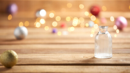 christmas lights and small antique glass bottle on wooden background
