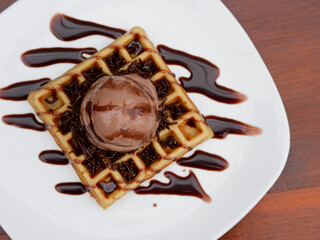 chocolate waffle with ice cream topping and chocolate sprinkles