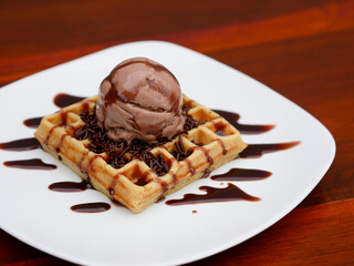 chocolate waffle with ice cream topping and chocolate sprinkles