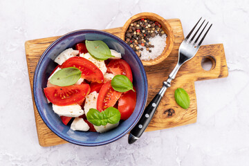Caprese salad with ripe tomatoes, mozzarella cheese and garden basil