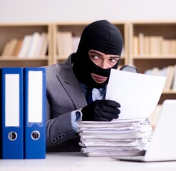 Criminal businessman wearing balaclava in office