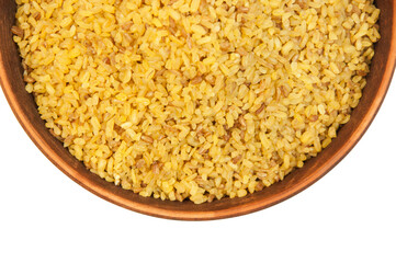 bulgur in a clay bowl on a white background. the concept of a good harvest of bulgur