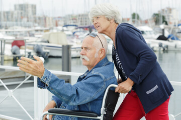 Fototapeta na wymiar senior couple in wheelchair in the port
