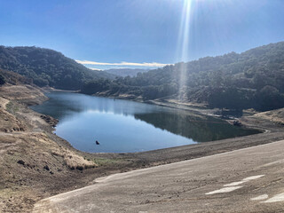 Concrete dam of almost dried, low water level Guadalupe Reservoir reservoir in San Francisco Bay...