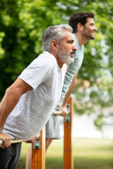 two motivated men doing dips exercise