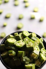 Bhindi fry. Farm fresh raw okra slices in a wooden bowl. Close up of chopped Lady Fingers or Okra. Copy space. Cut vegetables. Green healthy veg.