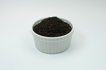 
tea leaves in a container with a white background