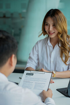 Young man handing resume to employer for job interview to review job application The concept shows the company's ability to agree on job positions, employees.