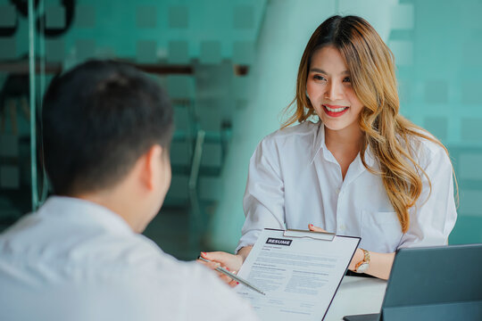 Young man handing resume to employer for job interview to review job application The concept shows the company's ability to agree on job positions, employees.