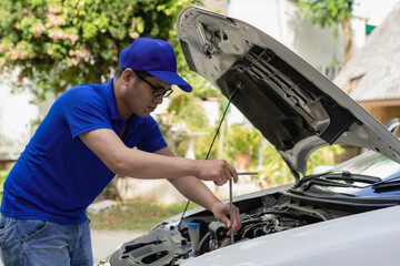 Home service mechanic checking car engine. Car service. Asian man opens his convertible and...
