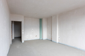 New empty room under construction. Plaster walls. New home. Concrete walls. Interior renovation.