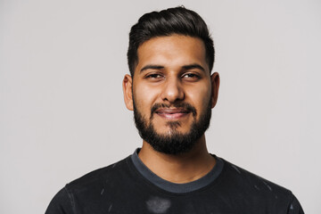 Young indian man with beard smiling and looking at camera