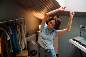 Young white woman smiling and dancing at home