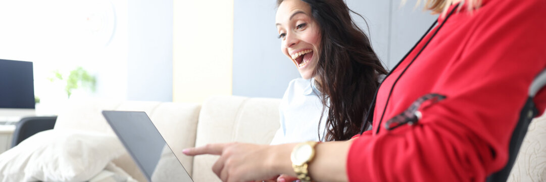 Friends spend time at home, watching movie and laughing, woman in wheelchair with laptop on lap