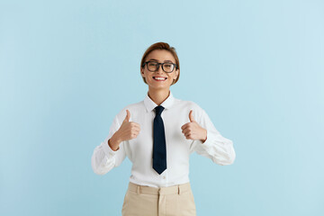 Smiling Businesswoman Showing Big Fingers Isolated. Happy Girl Looking at Camera with Toothy Smile and Showing Thumb Up, Approval Sign, Satisfied with Service, Good Feedback. Shot on Blue Background 