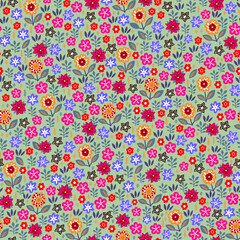 Amazing seamless floral pattern with bright multicolored flowers and leaves on a green background. An elegant template for fashionable prints. Modern floral background. Folk style.