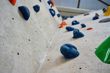 Wall for bouldering in gym with holds for climbing. Active extreme sport concept - obrazy, fototapety, plakaty