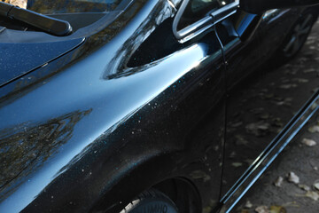 Details of modern car close up. The car is painted black with glitter