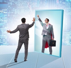 Businessman seeing himself in mirror as superhero