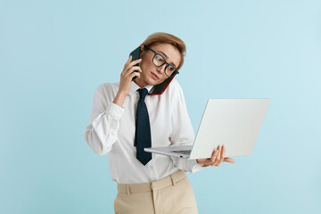 Busy Businesswoman Answering Calls Isolated. Caucasian Woman With Many Phones Feeling Stressful Holding Laptop. Lady Boss Talking Cellphone at Blue Background 
