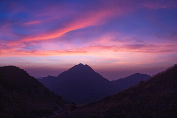 Dramatic sunset over the mountains at Sunset Peak, looking to Lantau Peak, Lantau Island, Hong Kong