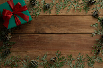 flat lay composition of christmas gifts and pine leaves on vintage wood table, top view
