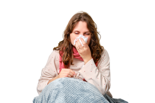 A sick woman blows her nose in a napkin, a runny nose, isolated on a white background. Adult ill woman with a red scarf sitting on a home bed in a white bedroom, female aged 35 years - Powered by Adobe