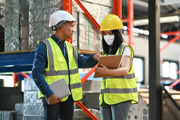 Warehouse workers are working in the retail warehouse full of shelves with goods. Manufacture storehouse occupation concept