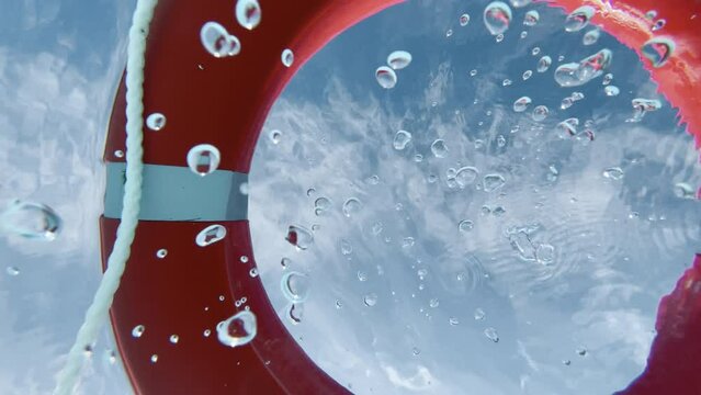 POV emerging from water through a red lifebuoy