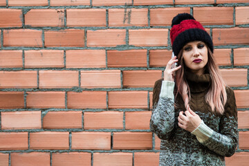 young girl with phone on the wall