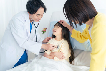 Obraz premium 入院している女の子を診察する医師 小児科医