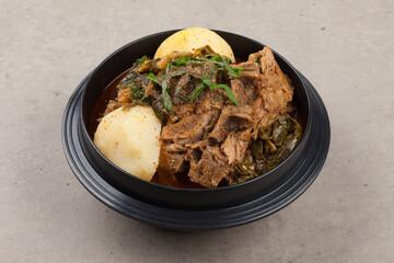 A stew boiled with spices such as potatoes, perilla seeds, green onions, and garlic in pork bones.돼지 뼈에 감자, 들깨, 파, 마늘 따위의 양념을 넣어 끓인 찌개.