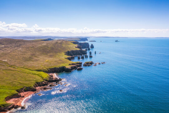 UK, Scotland, Aerial view of Saint Magnus Bay in summer with Drongs sea stacks in background