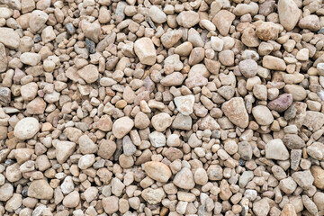 Abstract background with brown and beige dry stones, cobblestones, gravel. Gravel texture or background for design, for banner. Real grunge background texture and small stone. Close up, top view