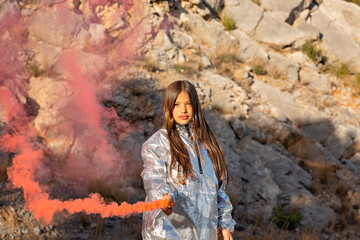 Girl holding distress flare in front of mountain