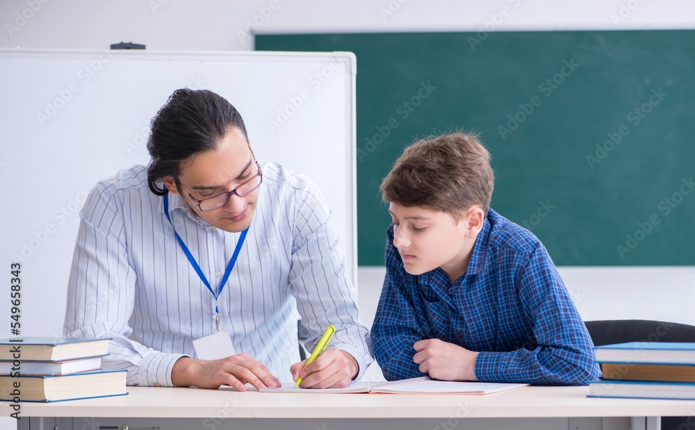 Wall mural Young male teacher and boy in the classroom