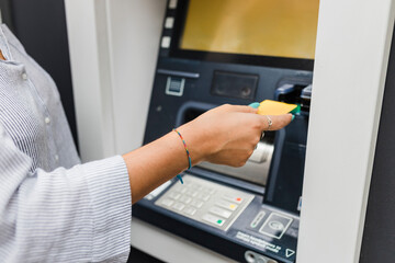 Hand of woman inserting credit card in ATM machine