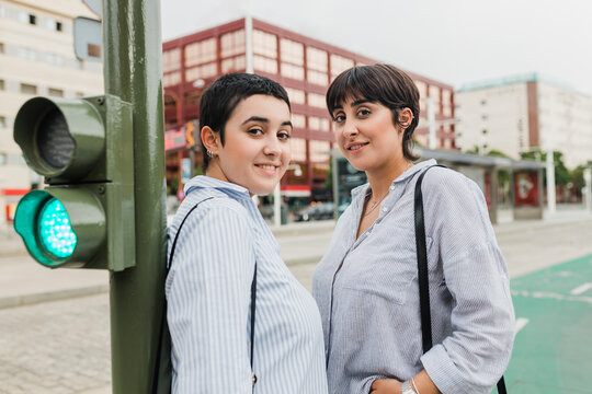 Young lesbian couple standing near stoplight