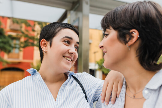 Smiling woman with hand on shoulder of lesbian girlfriend
