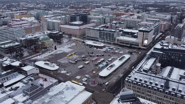 Central square of a mid sized European city on a cold and snowy day. Turku, Finland. Orbiting drone shot