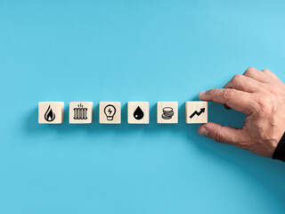 Rising energy prices or costs. Energy crisis and inflation concept. Hand arranging wooden cubes...