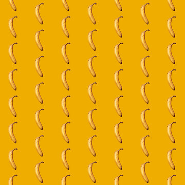 Pattern of bananas flat laid against yellow background