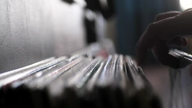 Looking Through Vinyl Records. Man Choosing Music to listen. Close up of hands flipping through vinyl records. Scene L.