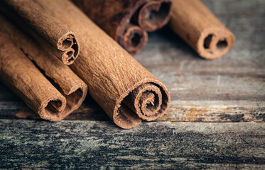 Close-up, fragrant cinnamon sticks on a wooden background.