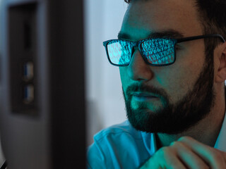 Programmer with eyeglasses hacking computer with virus