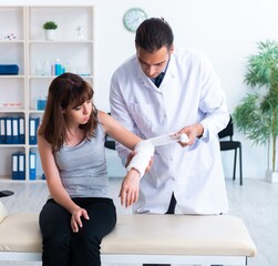 Obraz premium Young woman visiting male doctor traumatologist